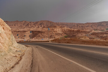 A view of the rocky and mountainous desert that is crossed by an asphalt road.