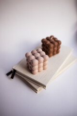 Different stylish bubble candles on books, close up. Space for text