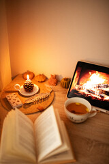Open book. Lit candle. Cup of tea and cozy atmosphere. Still life. Working atmosphere.