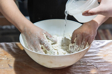 Detail of hands preparing dough
