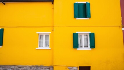 Colorful house facade on Burano Island, North Italy, features a vibrant yellow wall with minimalistic windows, creating a visually stunning view, house, vibrant