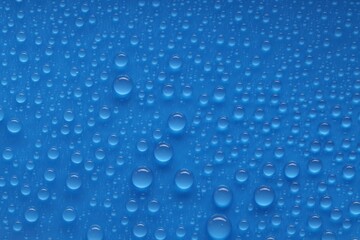 Water drops on blue background, top view