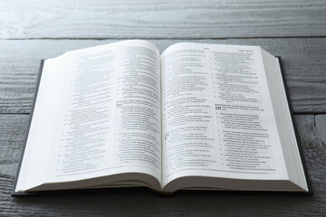 Open Holy Bible in English language on wooden table