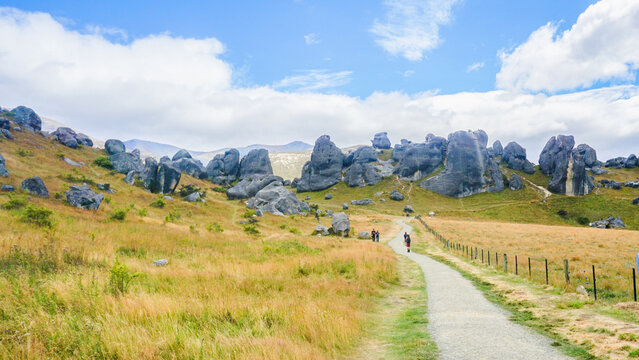 Castle Hill in New Zealand is a breathtaking landscape of majestic limestone rock formations, surrounded by rolling hills and dramatic mountain backdrops, perfect for adventurers and nature lovers ali