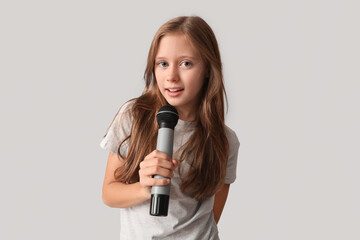 Cute girl with modern microphone on grey background