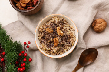 Bowl of traditional Ukrainian Kutya dish and Christmas tree branch on white background