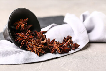 Overturned bowl with aromatic star anise and napkin on grunge table