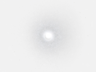 Bright central light surrounded by radiating particles in dark space.