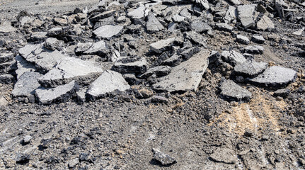 Natural black coal pile. Photograph of damaged asphalt road surface. Road maintenance. Stone. Transportation and communication. black asphalt texture. asphalt road. stone asphalt.