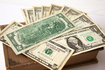 Collection of vintage US banknotes on an old book with historical significance and value