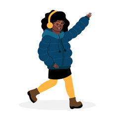 Young girl happily walking in winter attire while listening to music