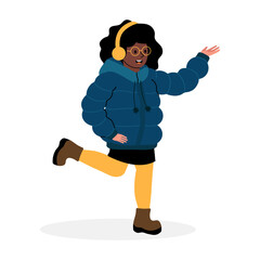 Young girl joyfully walking in winter clothing while listening to music