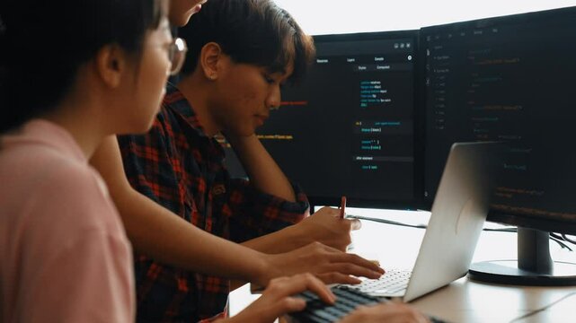 Slow motion back end software developer engineer for computer programming working together on debugging writing computing code, solving complex algorithms display on monitor in office. Burgeoning