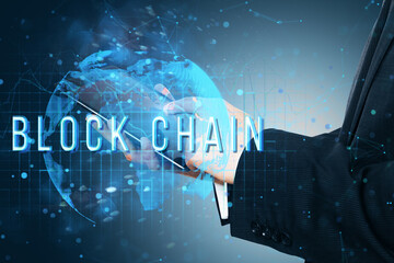 Hands holding tablet with blockchain text over holographic world map. Digital network concept of blockchain technology.