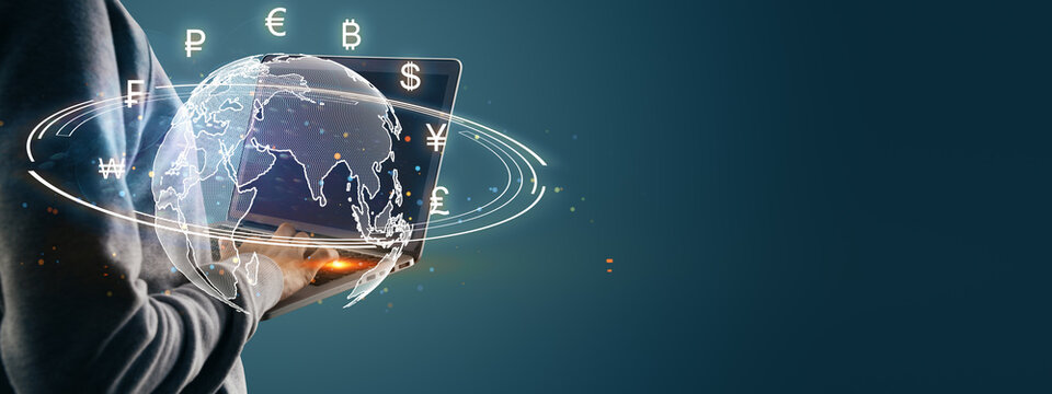 Person using laptop with digital world map and currency symbols around, concept of global finance and online currency exchange.
