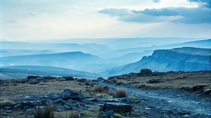 Obraz premium Misty blue landscape with rugged terrain, eerie atmosphere, moody tone, wild nature, blue misty landscape