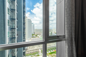 Glass windows in high-rise condos offer views of buildings.