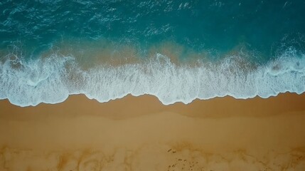 Ocean Waves Crashing on Sandy Beach: Aerial view of turquoise ocean waves gently rolling onto a sandy beach. Perfect for travel, summer, and nature themes. 
