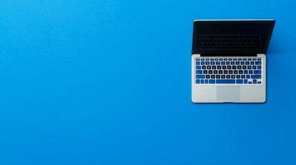 Laptop on Blue: A sleek silver laptop with a black screen rests on a vibrant blue background, creating a clean and modern visual. The image is perfect for showcasing technology, productivity.