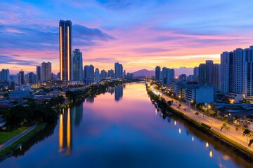 Fototapeta premium A cityscape reflected in a river under an azure dusk sky, with soft pink hues blending into the horizon