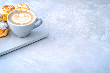 An abstract close up of latte art beside a selection of buttery pastries, placed on a modern countertop, coffee and bakery