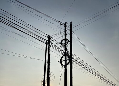 Internet cable installation poles in Indonesia. Silhouette of a pole and internet cable installation. Internet network. 