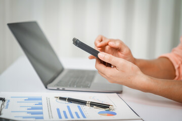 A close-up of a businesswoman working on a laptop in an office. As an accountant, she records financial data, verifies documents, manages income and expenses, ensuring accurate financial reporting