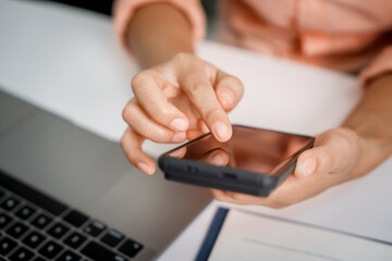 A close-up of a businesswoman working on a laptop in an office. As an accountant, she records financial data, verifies documents, manages income and expenses, ensuring accurate financial reporting