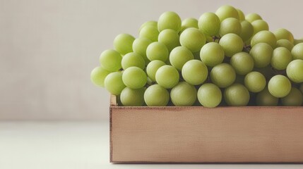 Fresh green grapes piled in a wooden box, showcasing their natural color and texture, ideal for healthy snacking or culinary uses.