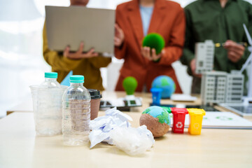 Asian business professionals discuss waste management and recycling strategies at desk, focusing on clean energy initiatives solar panels, electric cars, zero-waste solutions for sustainable future.