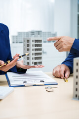Asian business professionals and lawyer meet at desk, discussing city planning and high-rise...