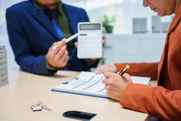 Asian business professionals and lawyer meet at desk, discussing city planning and high-rise building tax collection. They review contract papers, sign agreements, assess property tax and valuation.