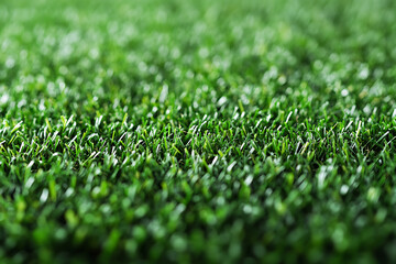 Artificial grass covers a well-maintained outdoor area in a sunny environment, conveying lush greenery
