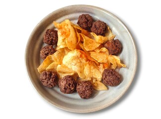 Top view of a plate of crispy potato chips lightly sprinkled with paprika, paired with tender homemade beef meatballs, creating a savory snack combination perfect for sharing or casual dining.