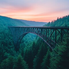 Bridge over lush green valley at sunset with vibrant sky colors.