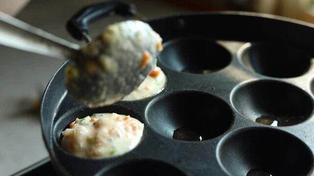 Appam or Mixed dal or Rava Appe South Indian dish preparation on iron pan