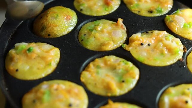 Appam or Mixed dal or Rava Appe South Indian dish preparation on iron pan