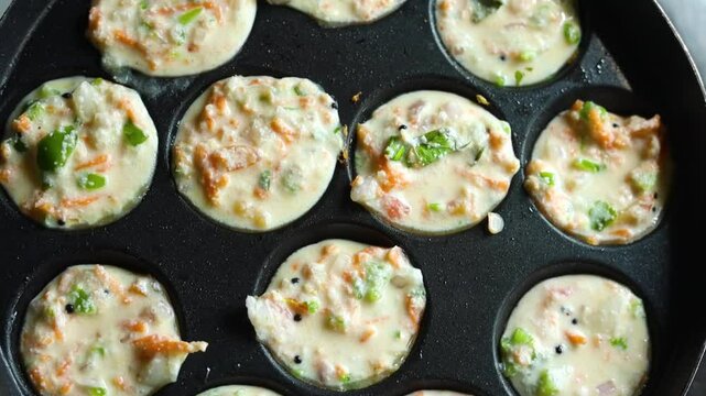 Appam or Mixed dal or Rava Appe South Indian dish preparation on iron pan