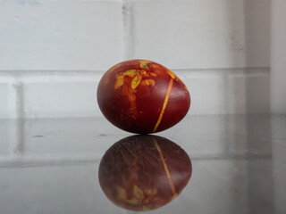 Easter eggs colored with plants and flowers boiled in onions peels on reflective table surface