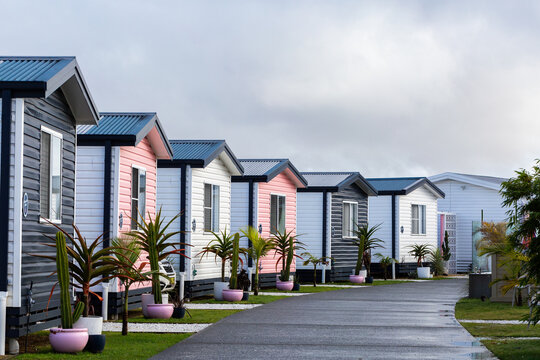 Coloured cabins in waterside accommodation park on overcast morning