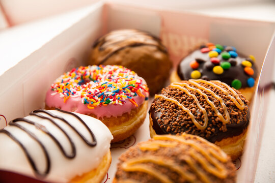 a cardboard box with 6 assorted doughnuts inside