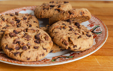 Chocolate chip cookies on a plate with a white background