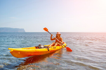 Kayak sea woman. Happy attractive woman with long hair in red swimsuit, swimming on kayak. Summer holiday vacation and travel concept.
