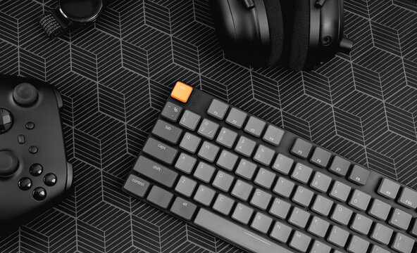 gamer work space concept, top view a gaming gear, mouse, keyboard, joystick on black table background.