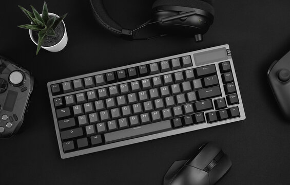 gamer work space concept, top view a gaming gear, mouse, keyboard, joystick on black table background.
