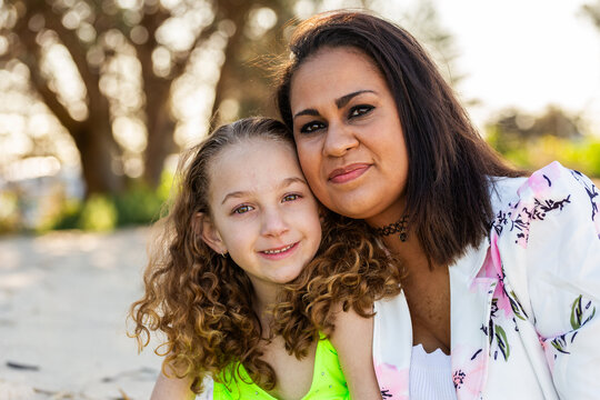 Portrait of Torres Strait Islander mother in her thirties and young daughter together on the beach