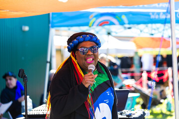 Torres Strait Islander woman singing at DJ booth at NAIDOC cultural event