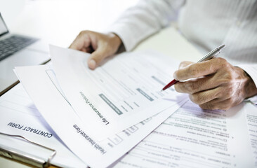 Asian man reading contract making deal with life insurance agent before sign. concept for consultant health insurance, life insurance savings plan, select focus at document