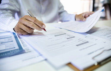 Asian businessman reviewing document reports at office workplace. legal expert, professional lawyer...