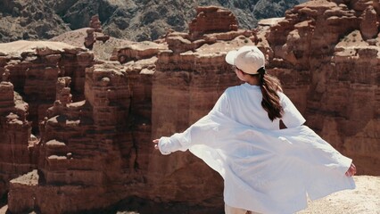 A teenage girl in the famous mountain valley of Kazakhstan. The wind in hot weather shakes your hair. She is enjoying her holidays.